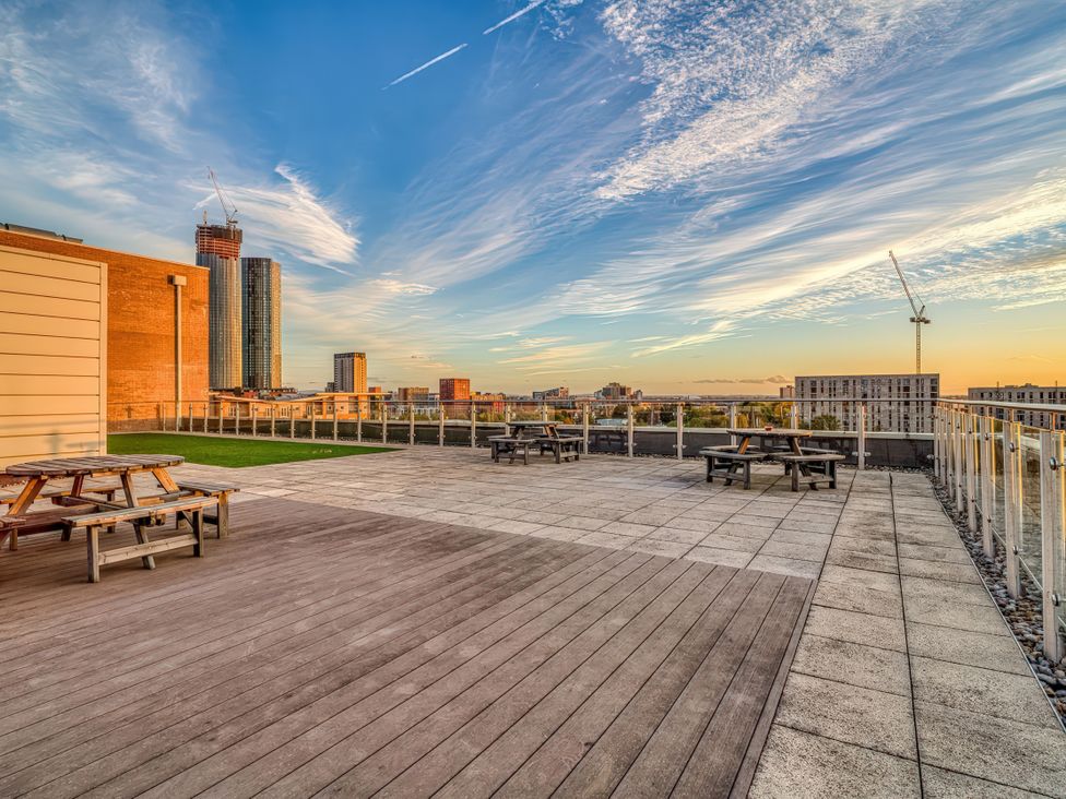 An outdoor terrace with tables and benches at Apartment 422 in Manchester