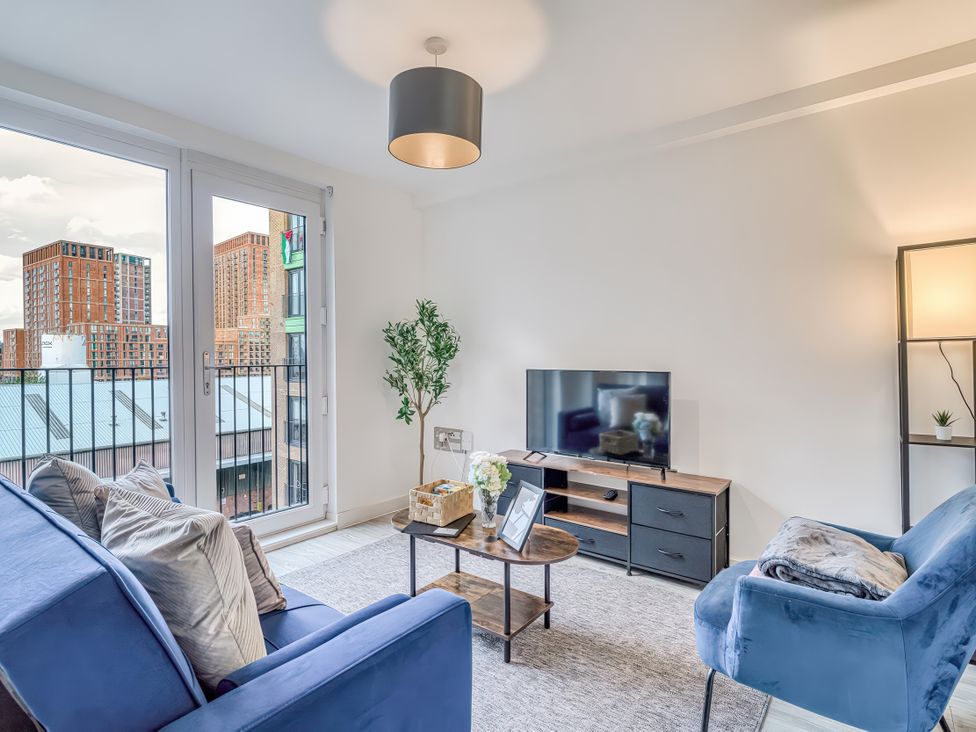A living room with sofas and a television at Apartment 422 in Manchester