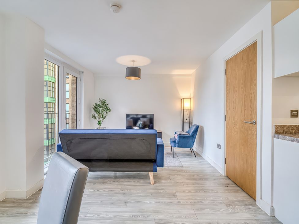 A living room with a sofa and television at Apartment 422 in Manchester