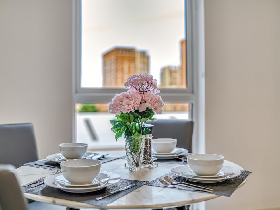 A dining table with a flower vase and bowls at Apartment 422 in Manchester