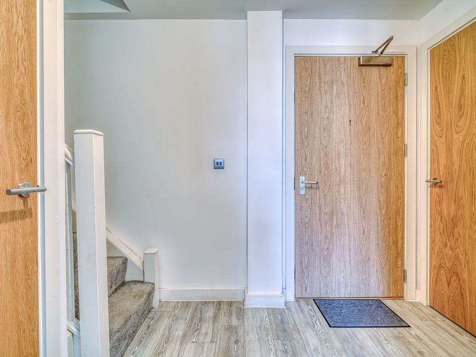 A hallway with a staircase and doors at Apartment 422 in Manchester