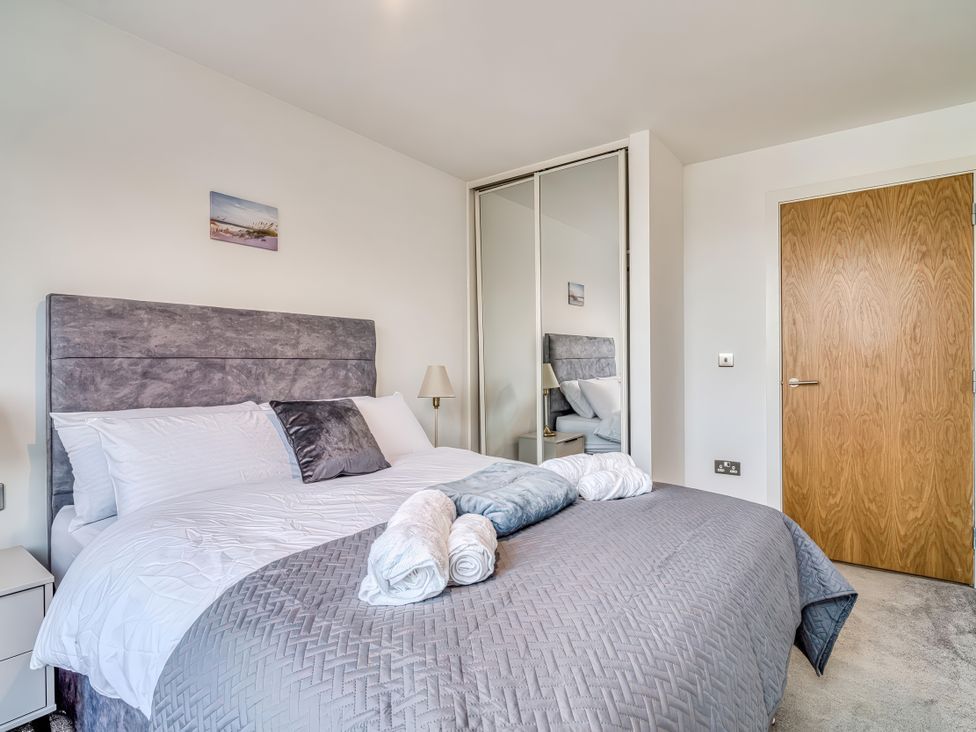 A bedroom with a bed and nightstand at Apartment 422 in Manchester