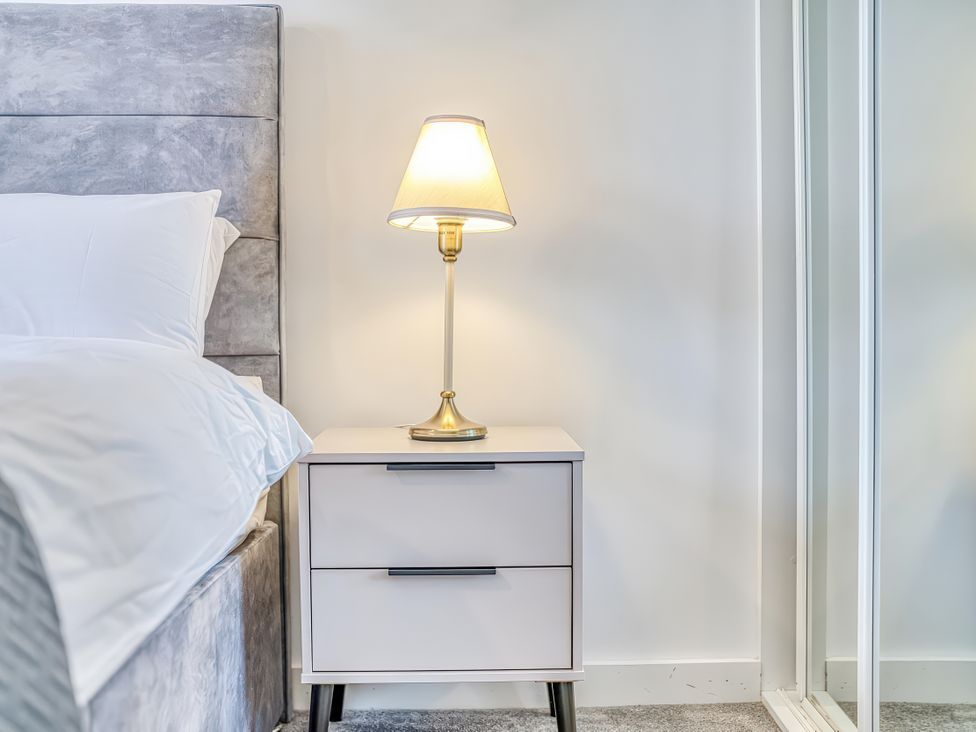 A bedroom with a nightstand and lamp at Apartment 422 in Manchester