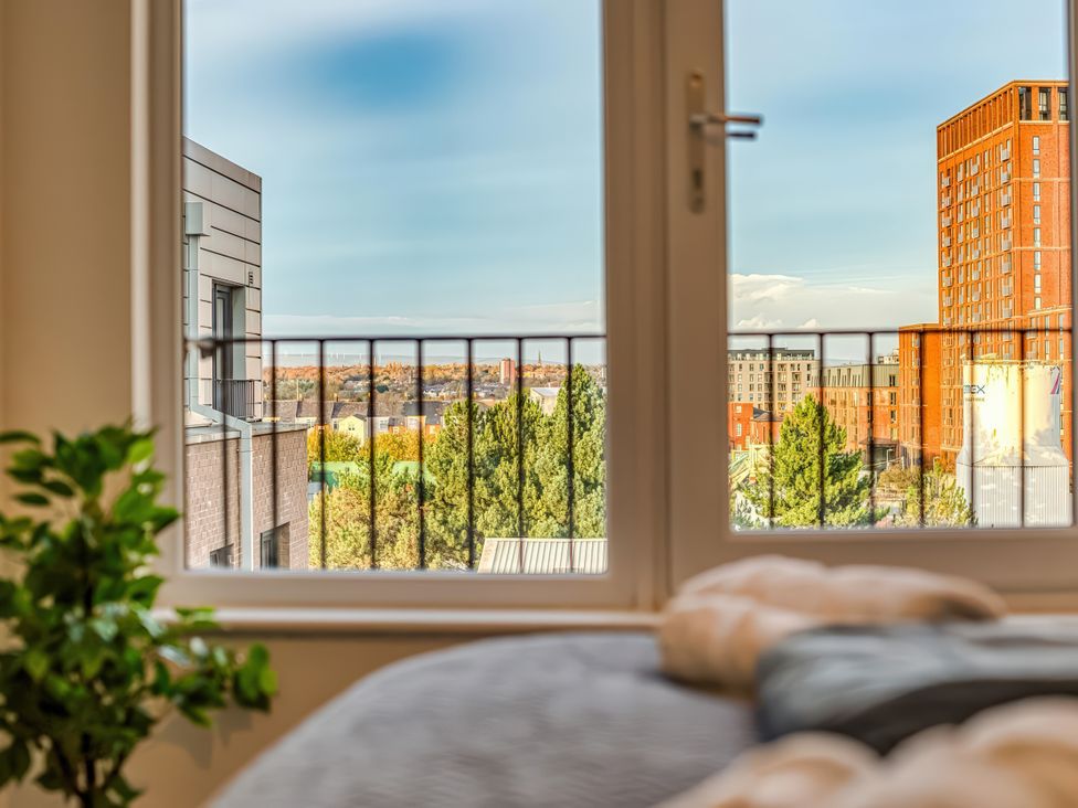 A view from a bedroom window looking at buildings and trees at Apartment 422 in Manchester