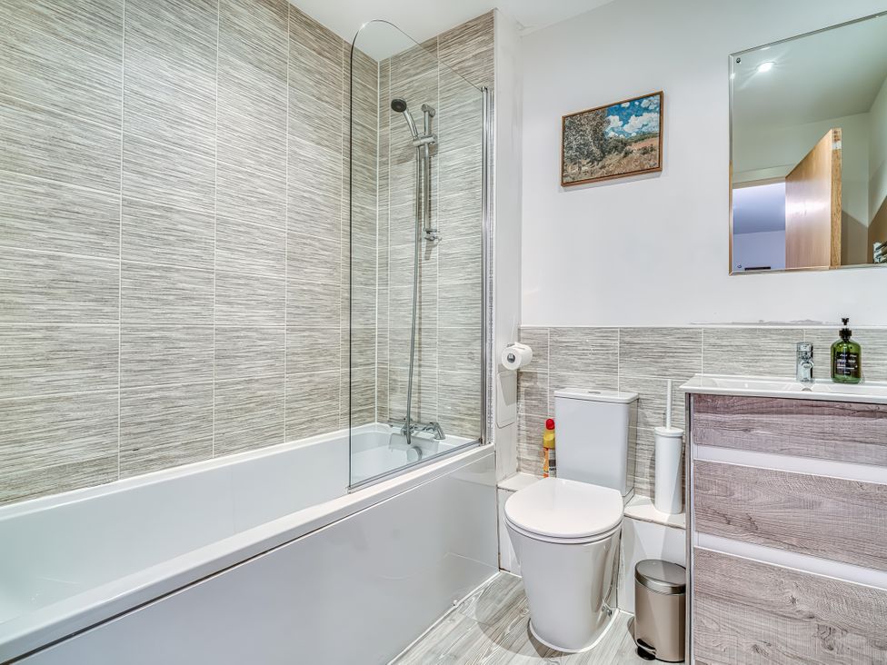 A bathroom with a bathtub, toilet, and sink at Apartment 422 Manchester