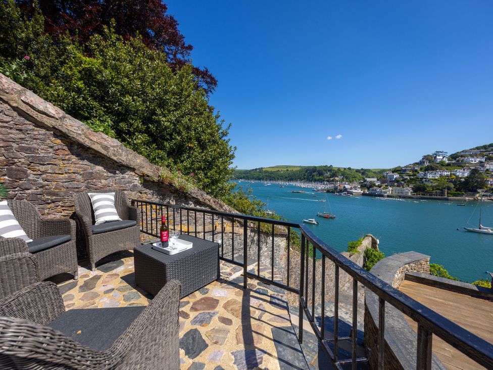 An outdoor seating area overlooking the water at Bell Cottage in Dartmouth