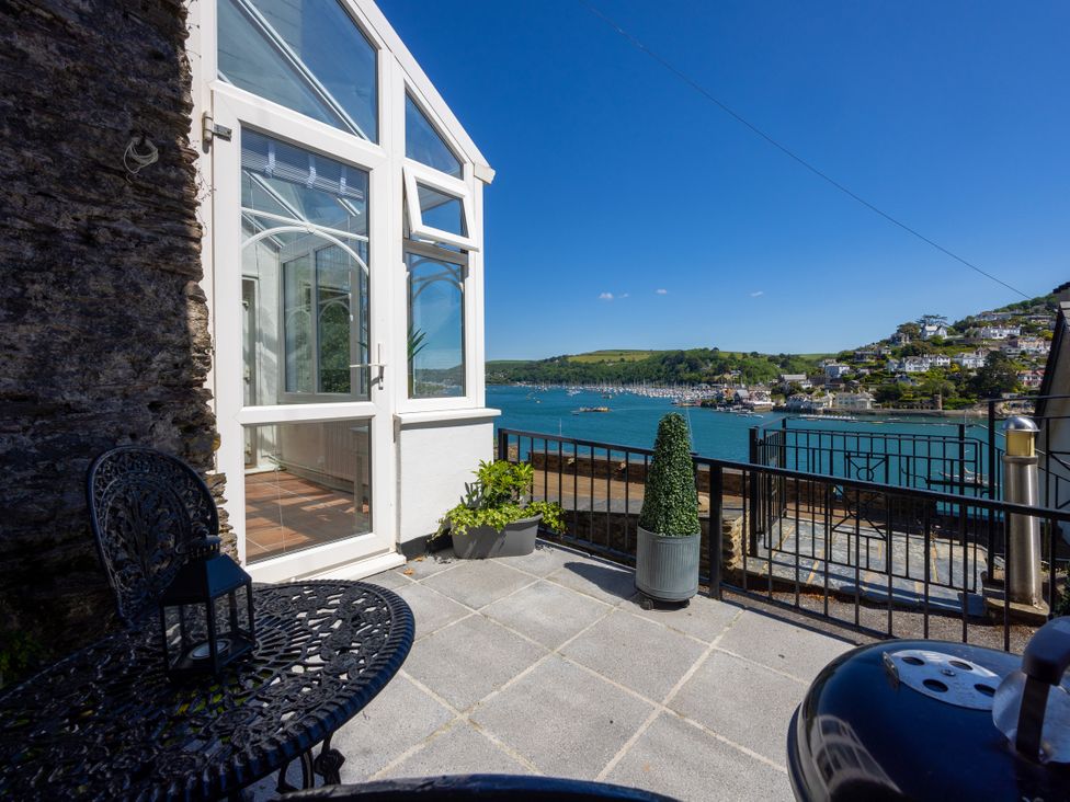 An outdoor area with a greenhouse and seating at Bell Cottage in Dartmouth