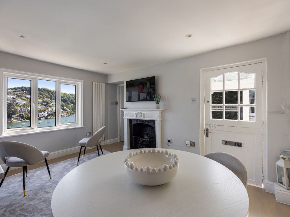 A living room with a fireplace and a view at Bell Cottage in Dartmouth