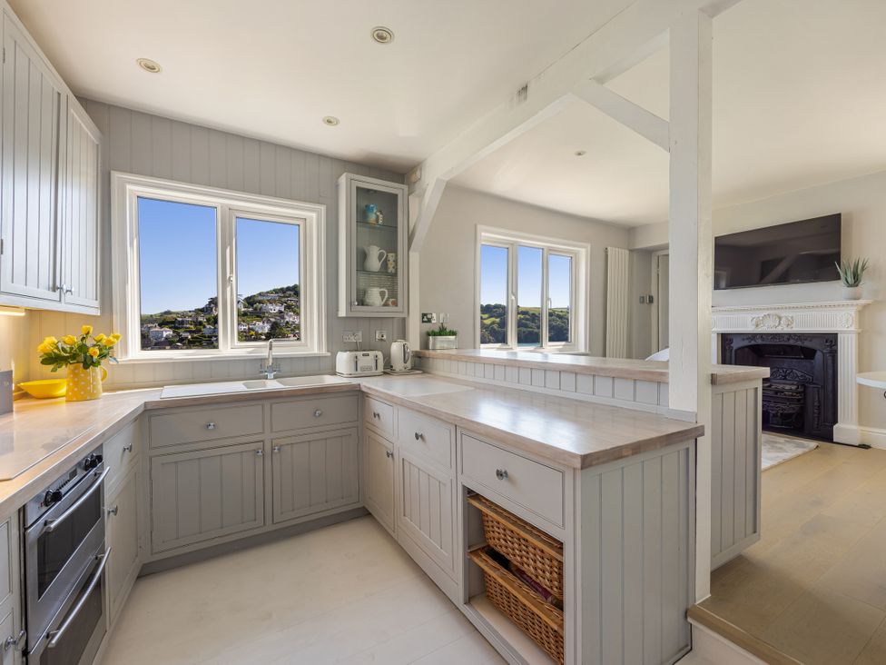 A kitchen with a window and cabinets at Bell Cottage in Dartmouth