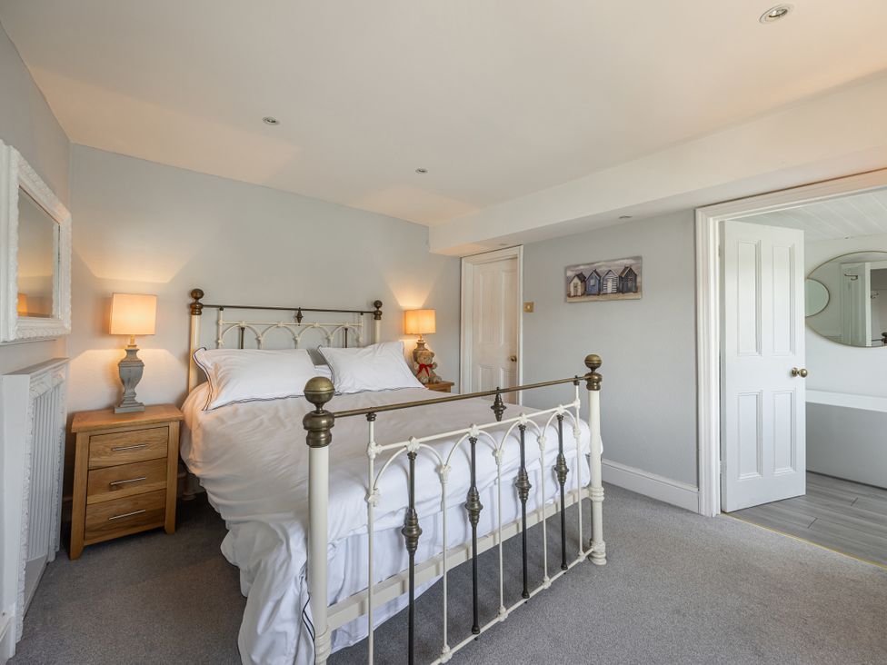 A bedroom with a bed and nightstands at Bell Cottage in Dartmouth