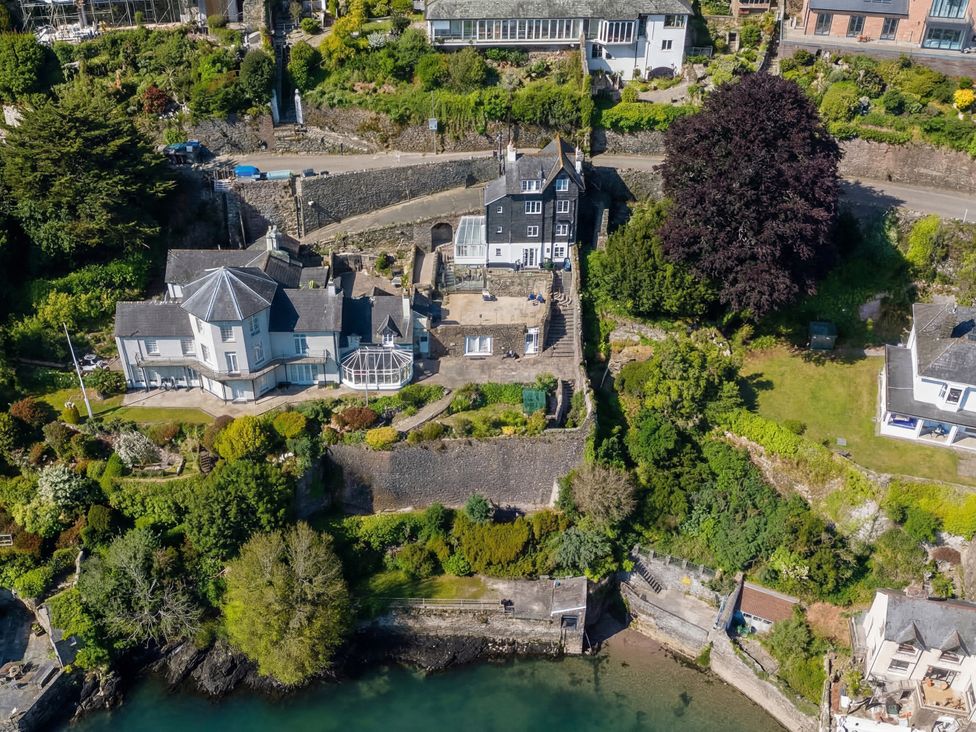 An aerial view of a house with garden near water at Bell Cottage Dartmouth
