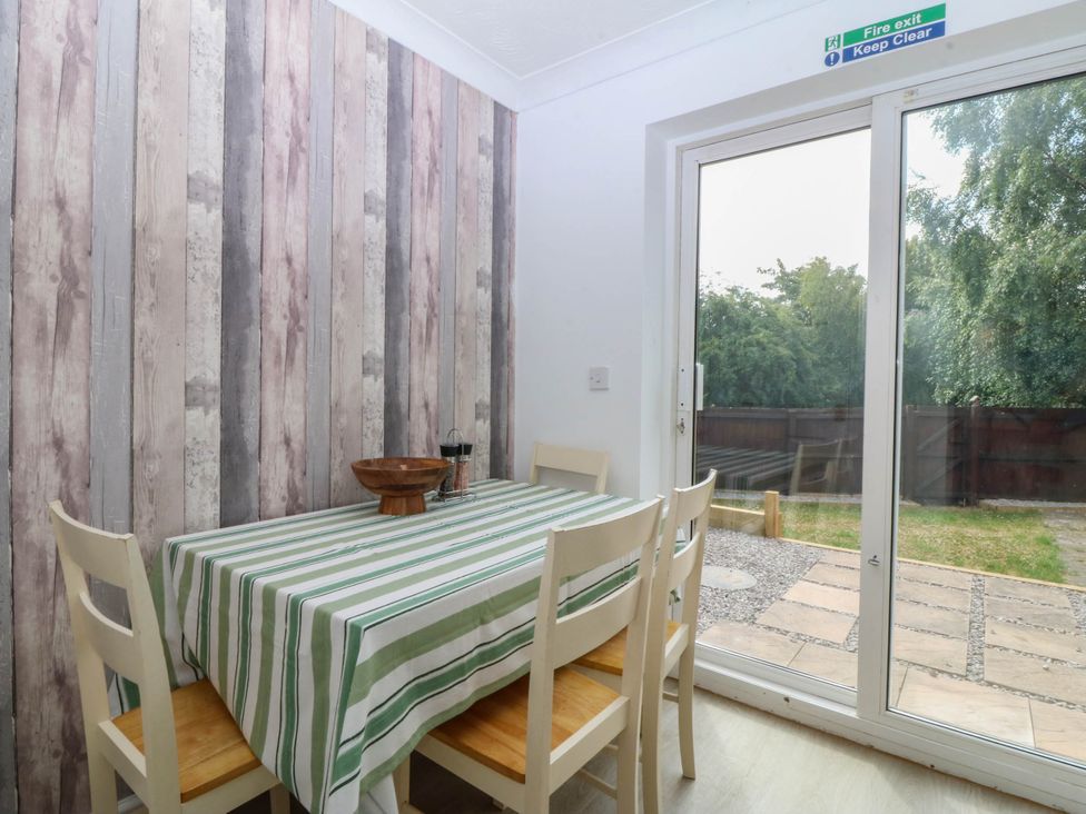 A dining room with a table and chairs at Meadow View in Kinmel Bay