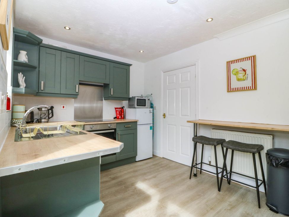 A kitchen with cabinets and a microwave at Meadow View in Kinmel Bay