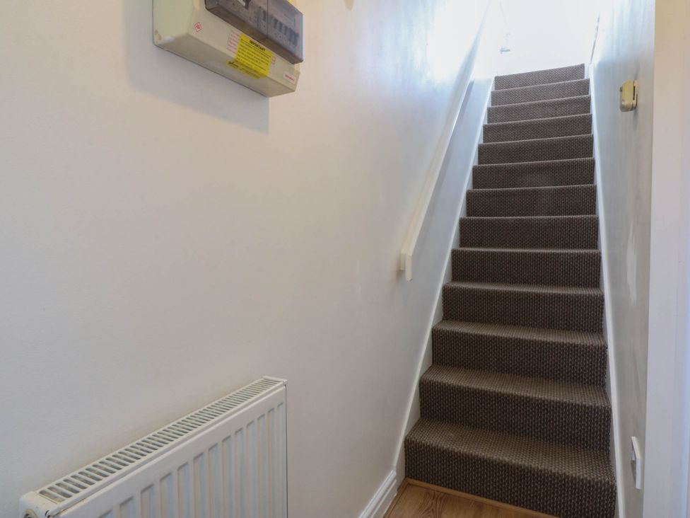 A hallway with stairs and a radiator at Meadow View in Kinmel Bay