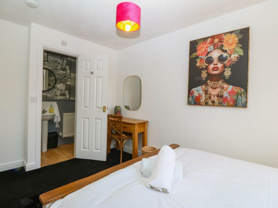 A bedroom with a bed and a painting at Meadow View in Kinmel Bay