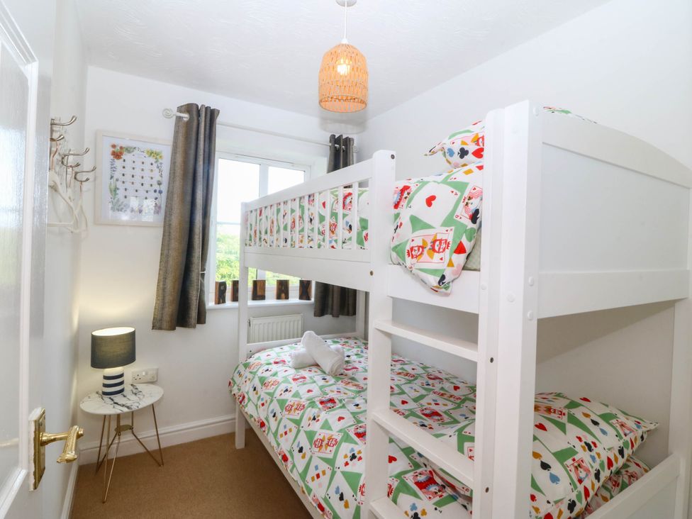 A bedroom with a bunk bed and decorative wall art at Meadow View in Kinmel Bay
