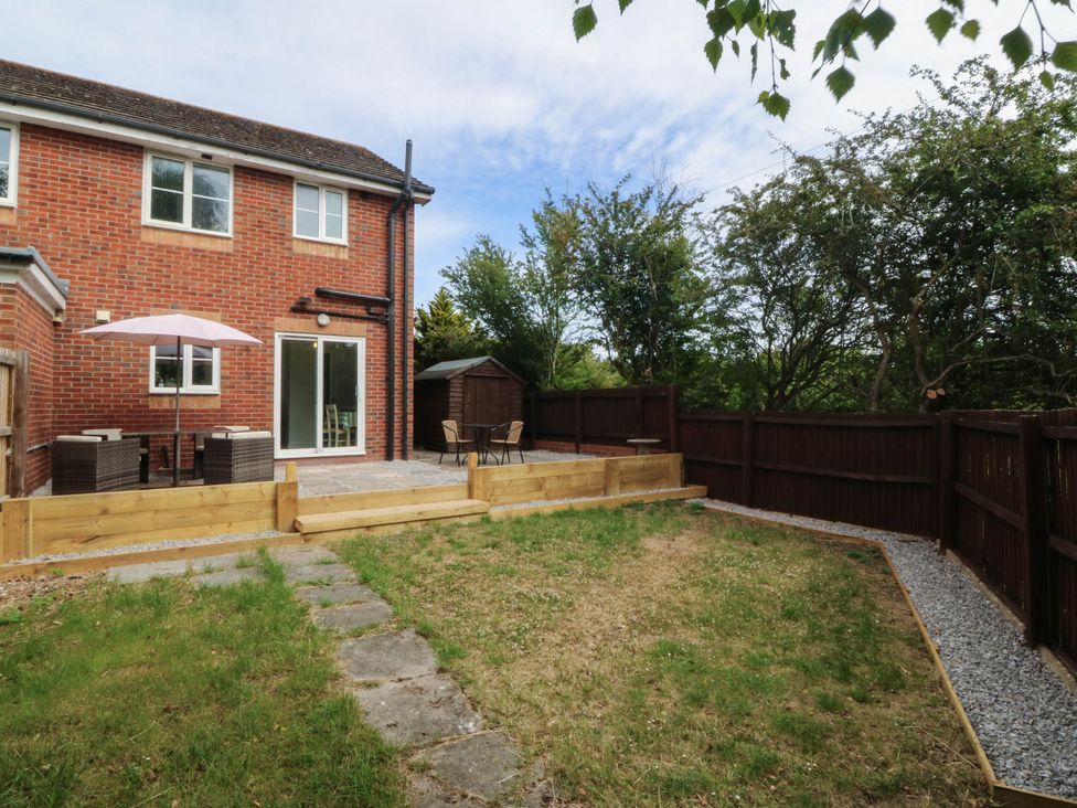 A garden with a patio and furniture at Meadow View in Kinmel Bay