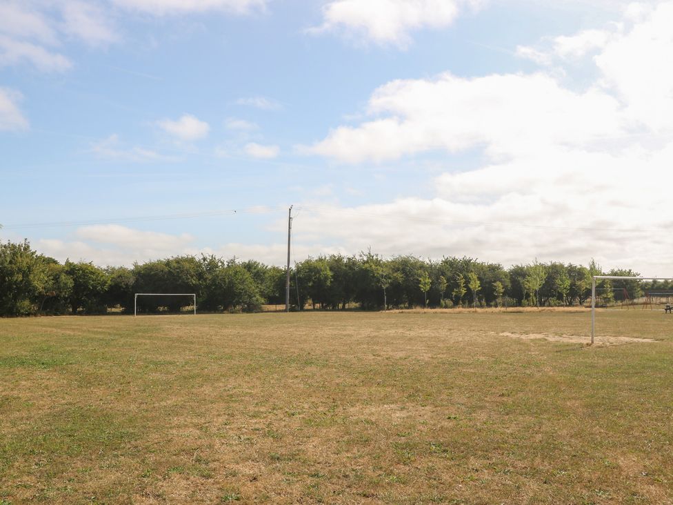 An outdoor football field with a goal and trees at Meadow View in Kinmel Bay