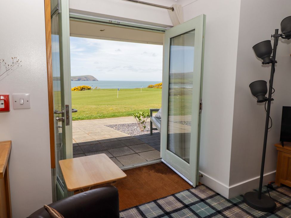 A living room with doors leading to an outdoor view at Ty Mor, Newport, Pembrokeshire