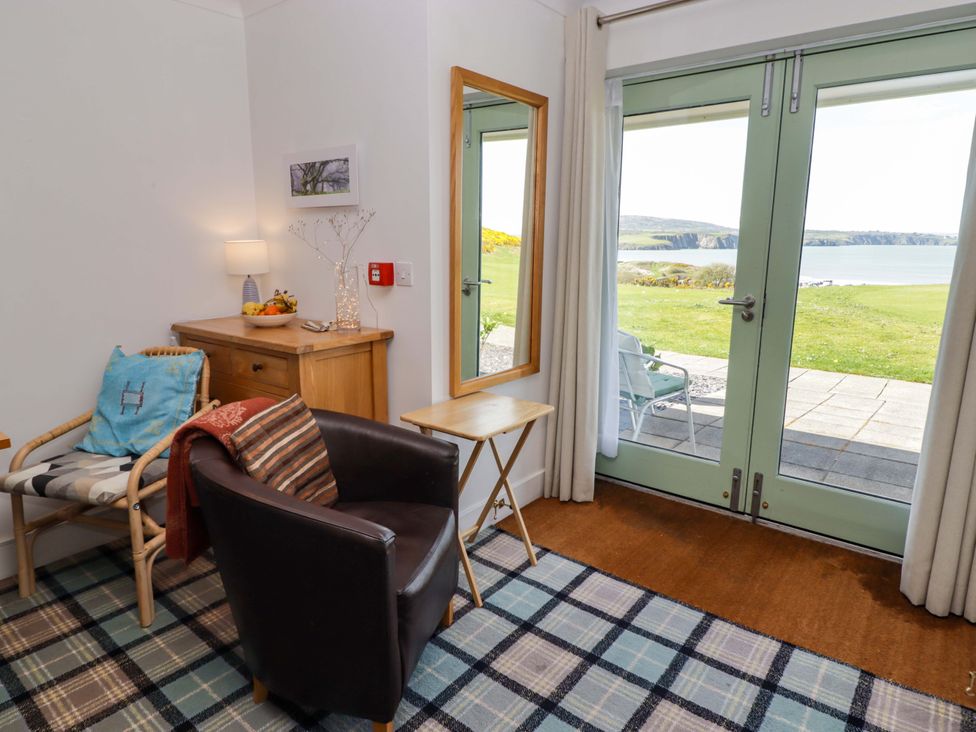 A living room with a chair and a side table at Ty Mor in Newport, Pembrokeshire