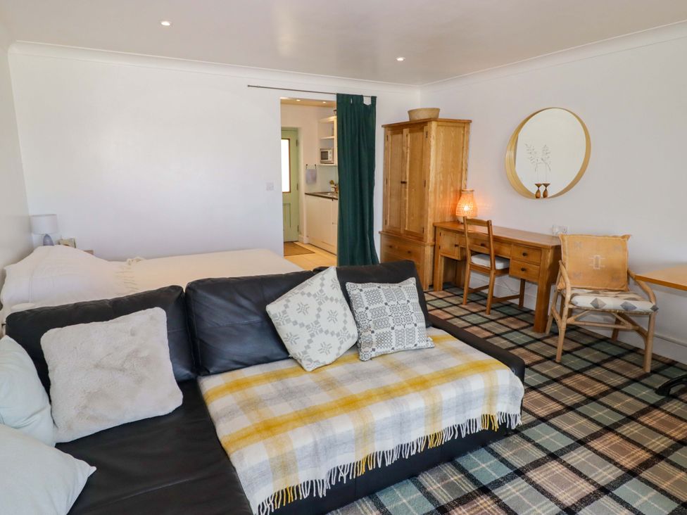 A living room with a sofa and desk at Ty Mor Newport, Pembrokeshire