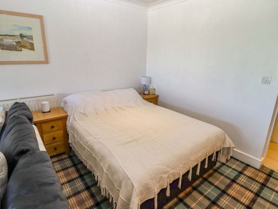 A bedroom with a bed and side table at Ty Mor in Newport, Pembrokeshire