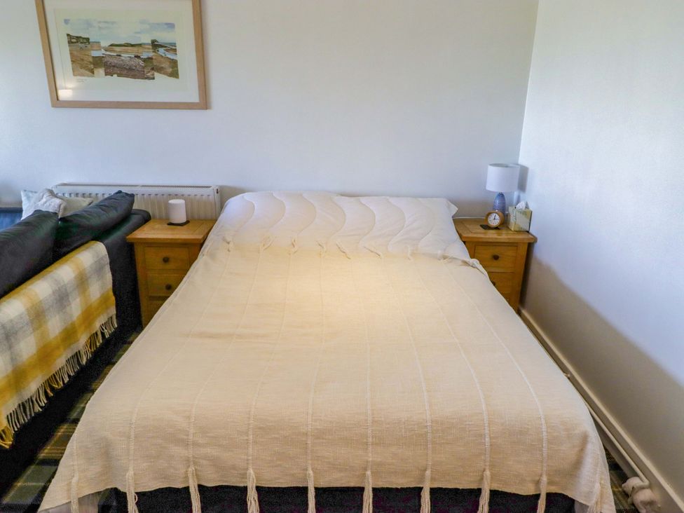 A bedroom with a bed and nightstand at Ty Mor in Newport, Pembrokeshire