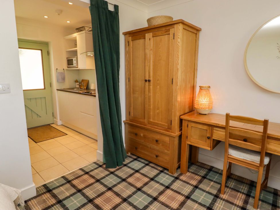A living room with a wooden cabinet and table at Ty Mor in Newport, Pembrokeshire