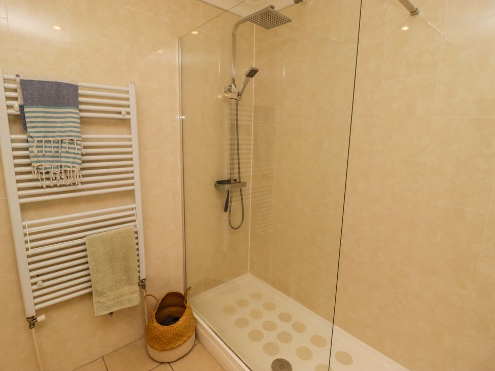 A bathroom with a shower and towel rack at Ty Mor in Newport, Pembrokeshire