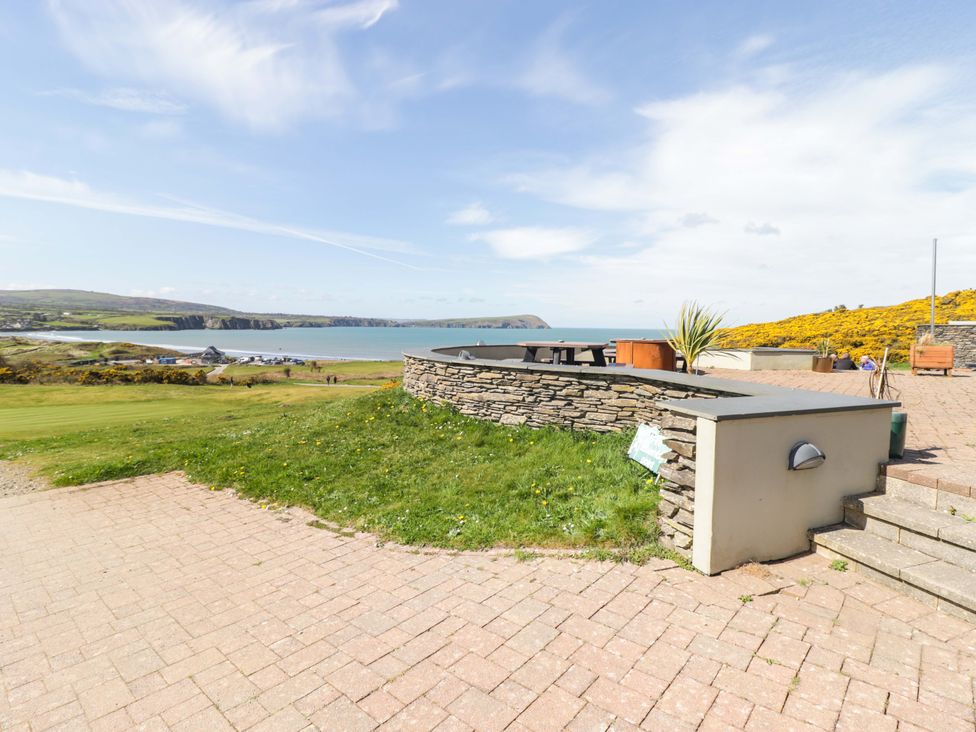 An outdoor area with a stone wall and view of the sea at Ty Mor in Newport, Pembrokeshire