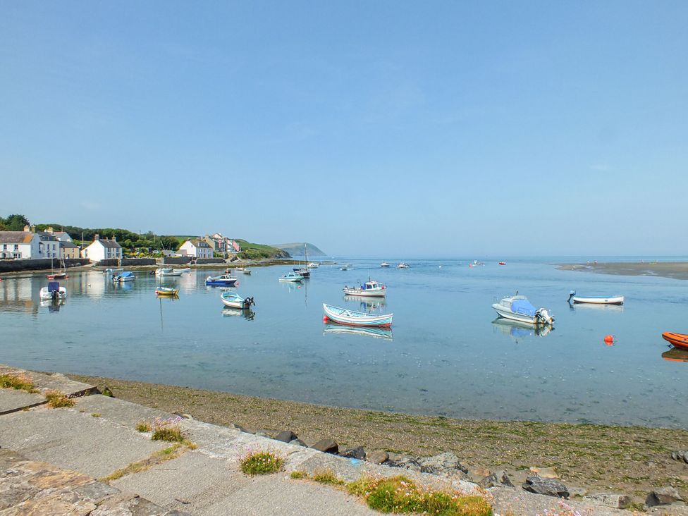 A view of boats on water with houses along the shore at Ty Mor in Newport, Pembrokeshire