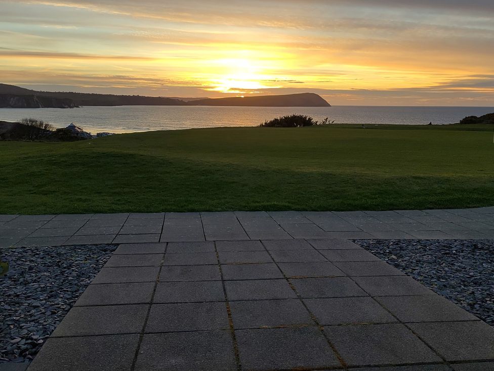 A view of the sunset over the ocean from an outdoor area at Ty Mor in Newport, Pembrokeshire