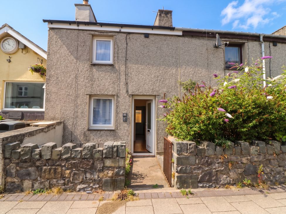 A house entrance with a door and stone wall at Emily Rose Cottage Bangor
