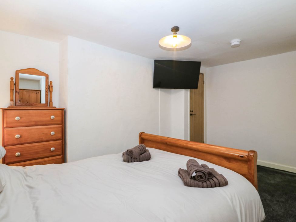 A bedroom with a bed and dresser at Emily Rose Cottage in Bangor