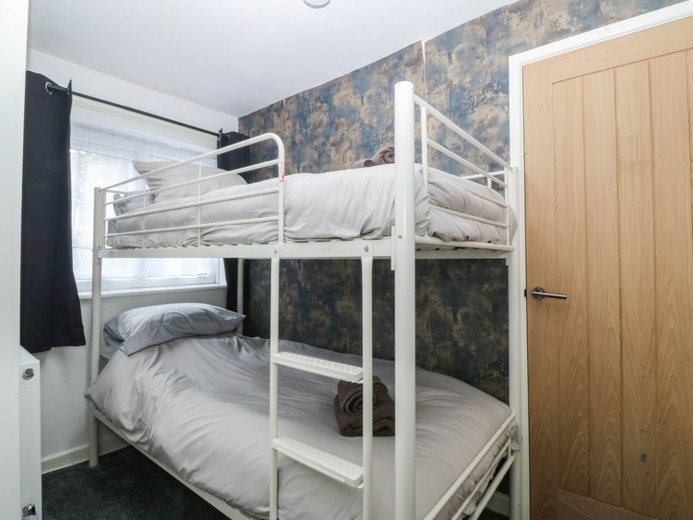 A bedroom with a bunk bed and window at Emily Rose Cottage Bangor