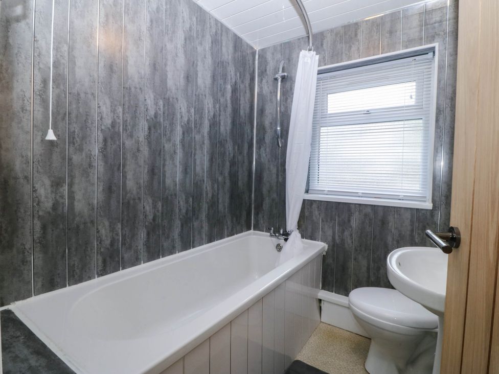 A bathroom with a bathtub and toilet at Emily Rose Cottage in Bangor