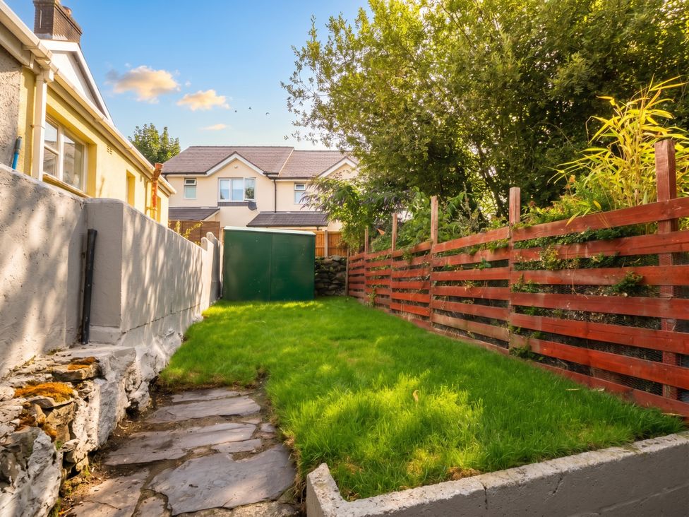 A garden with grass and a shed at Emily Rose Cottage in Bangor