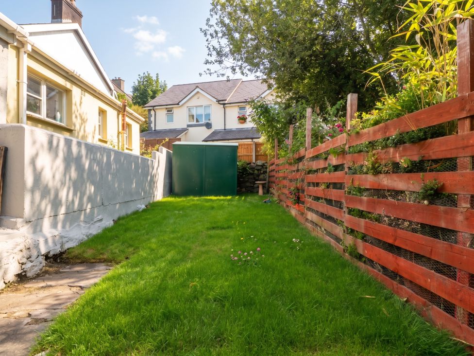 A garden with grass and a shed at Emily Rose Cottage in Bangor