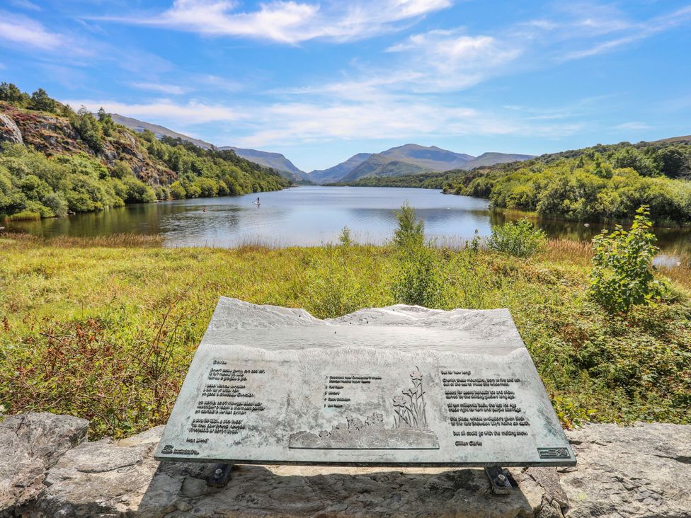 A lake with trees and mountains in the background at Emily Rose Cottage Bangor