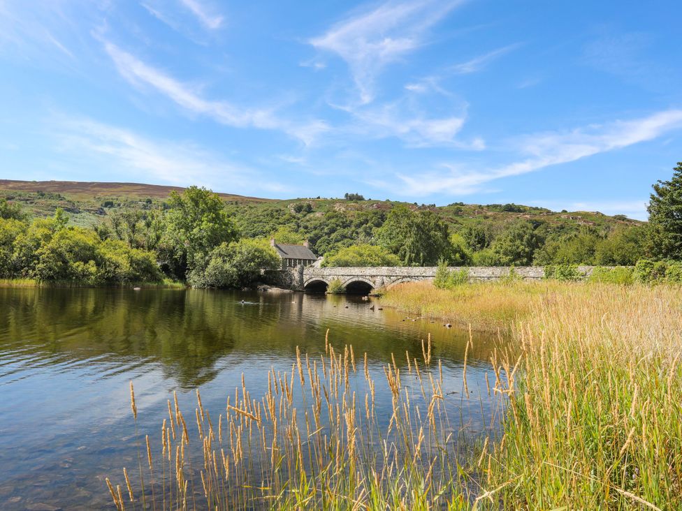 A bridge over water surrounded by grass and trees at Emily Rose Cottage in Bangor