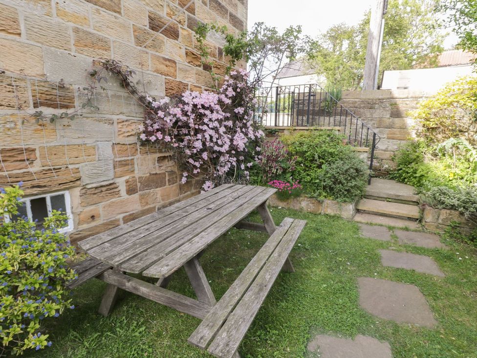 A garden with a wooden table and flowers at Mulgrave House in Saltburn-by-the-Sea