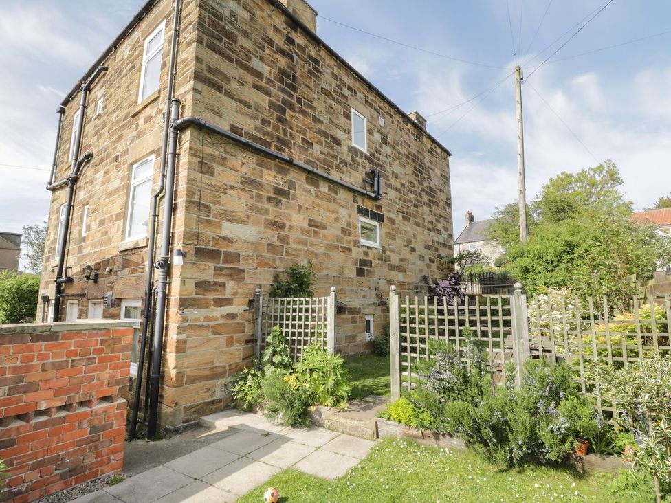 An exterior view of a stone house with a garden at Mulgrave House in Saltburn-by-the-Sea