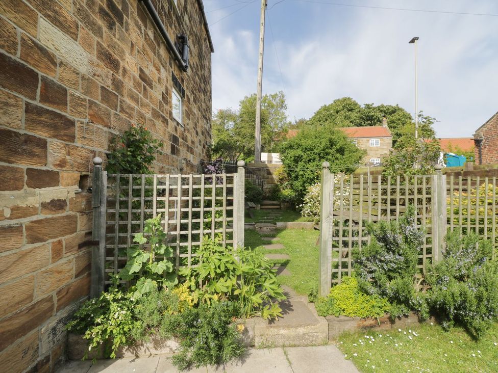 A garden with a gated pathway and plants at Mulgrave House Saltburn-by-the-Sea