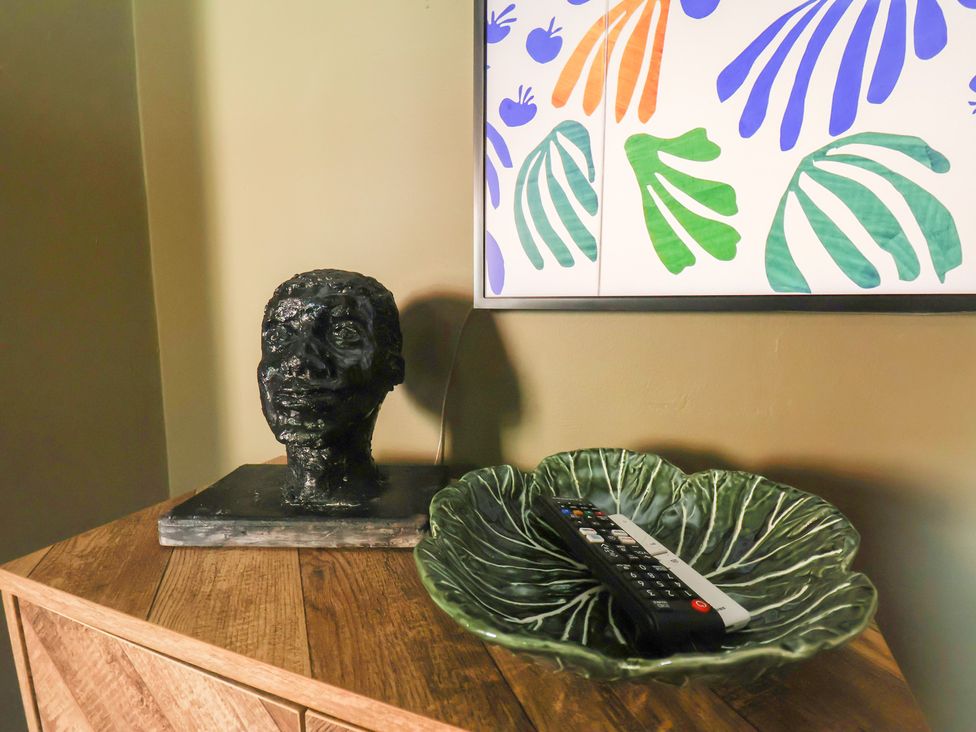 A living room with a sculpture and a remote control in a decorative bowl at Mulgrave House in Hinderwell near Staithes