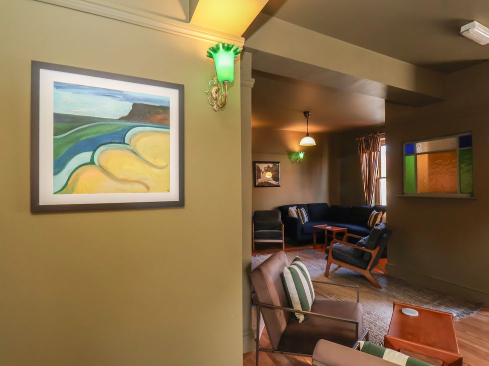 A living room with a painting on the wall and a sofa at Mulgrave House Hinderwell near Staithes