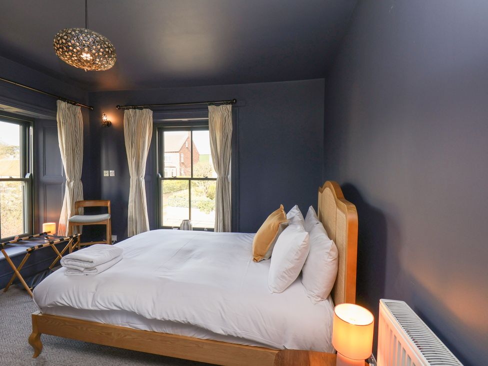 A bedroom with a bed and chair at Mulgrave House in Hinderwell near Staithes