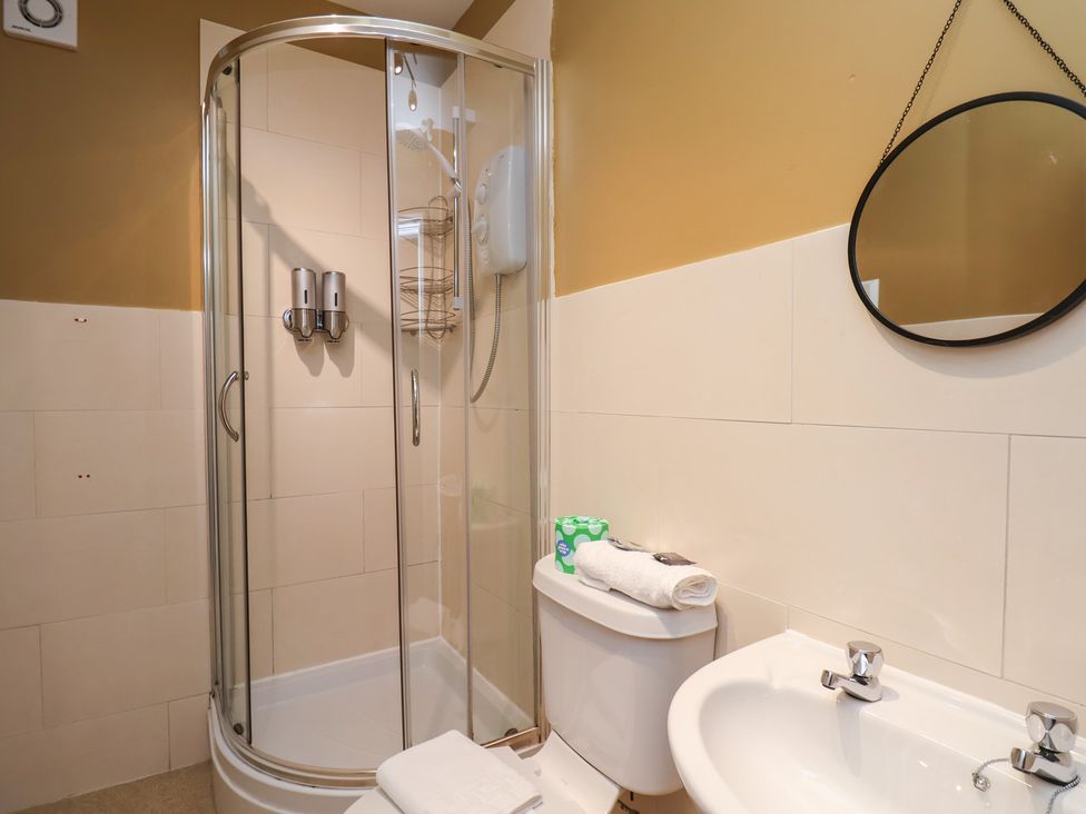 A bathroom with a shower, toilet, and sink at Mulgrave House in Hinderwell near Staithes