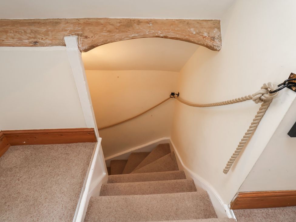A staircase with carpet and handrail at Mulgrave House in Hinderwell near Staithes