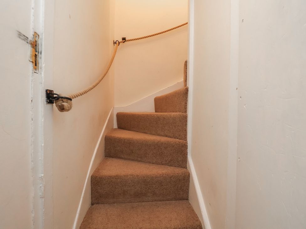 A staircase with carpet and handrail at Mulgrave House in Hinderwell near Staithes