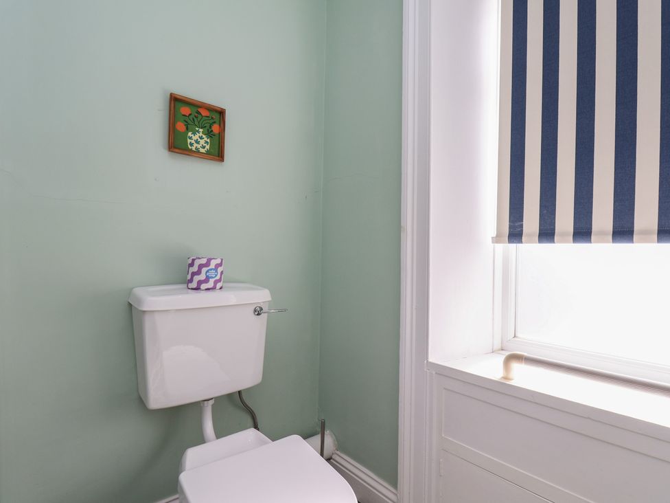 A bathroom with a toilet and wall art at Mulgrave House in Hinderwell near Staithes